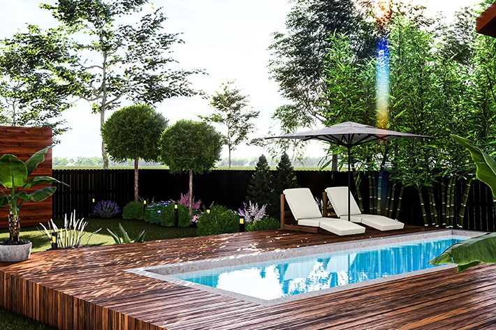 Luxurious in-ground pool with wooden deck surrounded by lush garden.