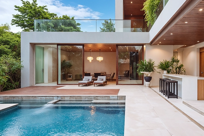 Modern house with a luxurious swimming pool and patio area.